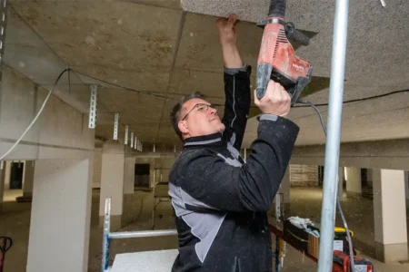 Nietiedt-Mitarbeiter bringt Wärmedämmung in Tiefgarage an